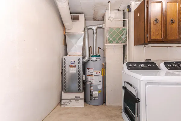 a utility room with fridge dryer and washer