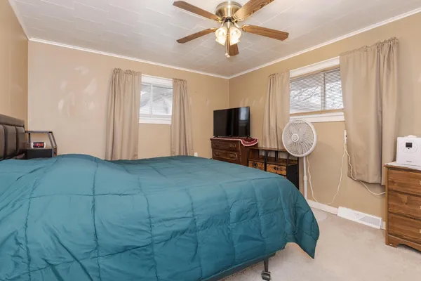 a bedroom with a bed closet and flat tv screen on dresser