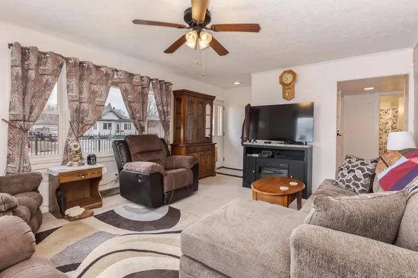 a living room with furniture a ceiling fan and a window
