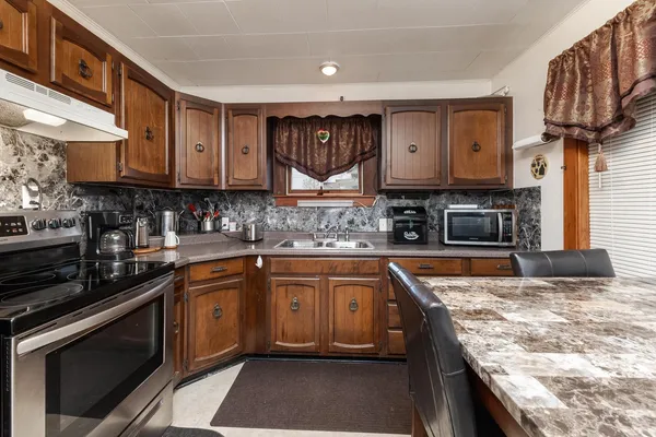 a kitchen with stainless steel appliances granite countertop a sink stove and cabinets