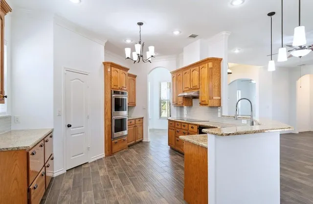 a view of a livingroom with a ceiling fan fireplace and wooden floor
