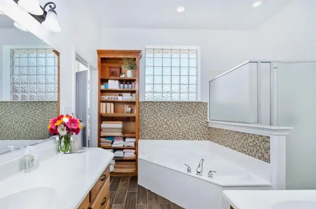 an empty room with wooden floor staircase and windows