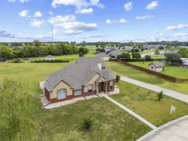 an aerial view of a house with swimming pool and green space