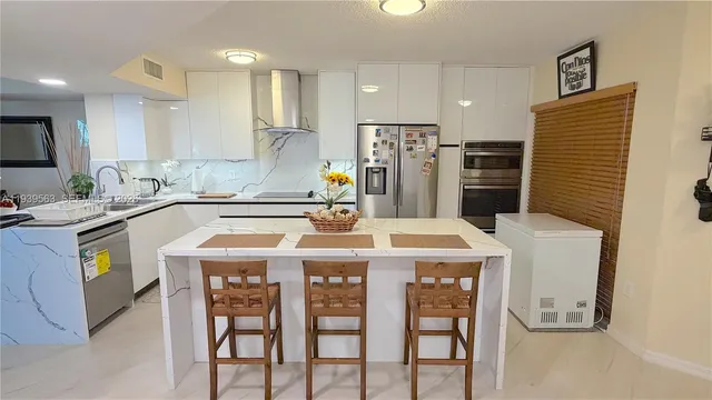 a kitchen with a sink a stove a refrigerator and a dining table