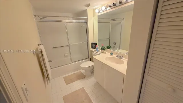 a bathroom with a sink a toilet a mirror and shower