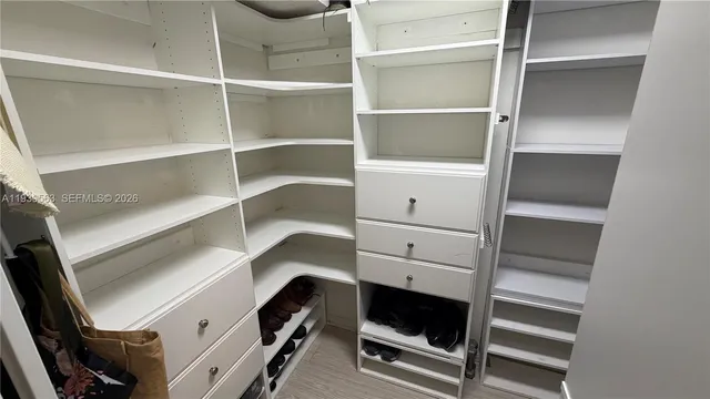 a view of walk in closet with empty racks