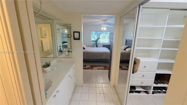 a hallway with white cabinets and wooden floor