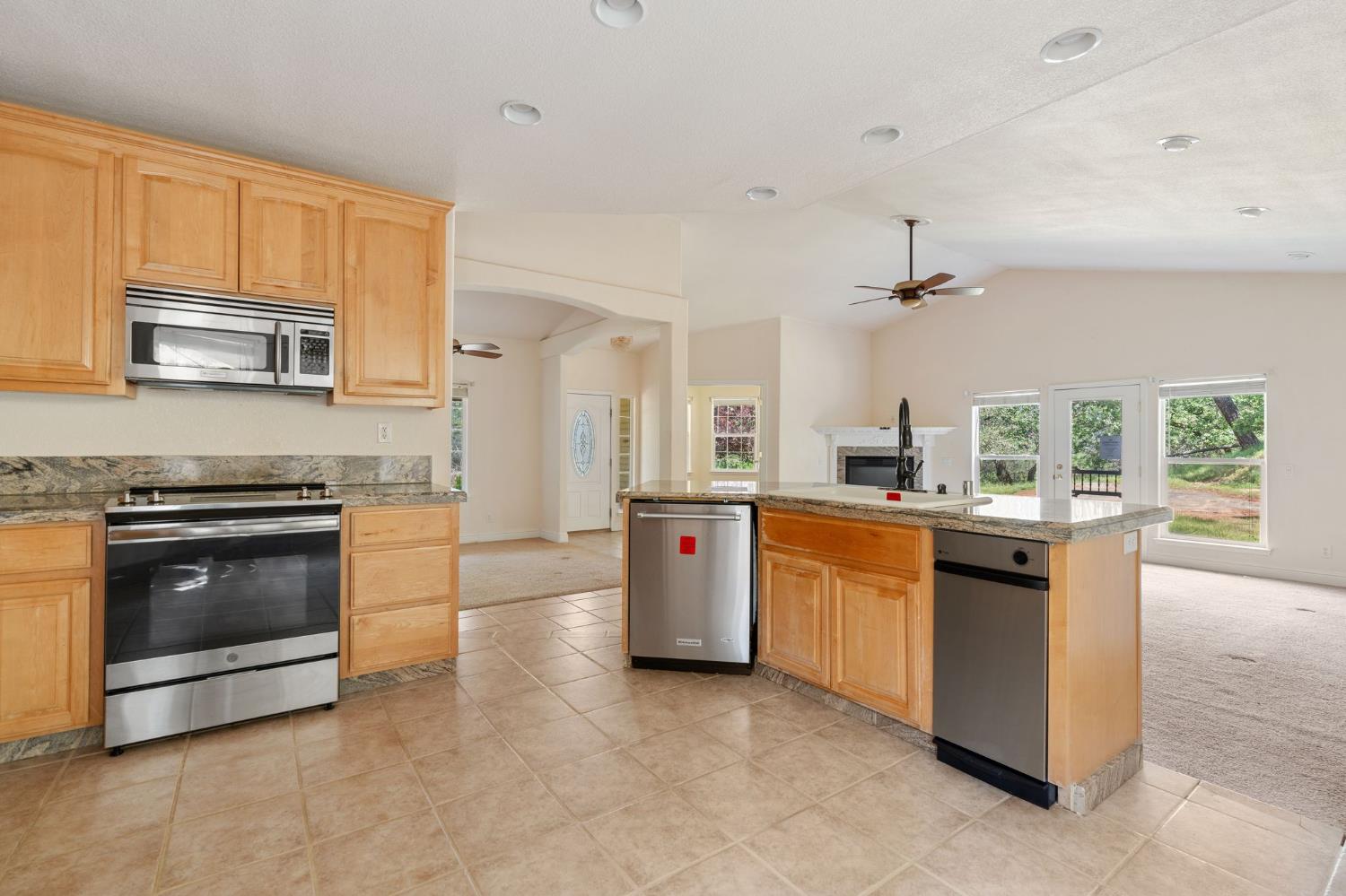 4410 Rossler Road Placerville, CA 95667 - Photo 16 of 35 a kitchen with stainless steel appliances granite countertop a stove a sink and a microwave