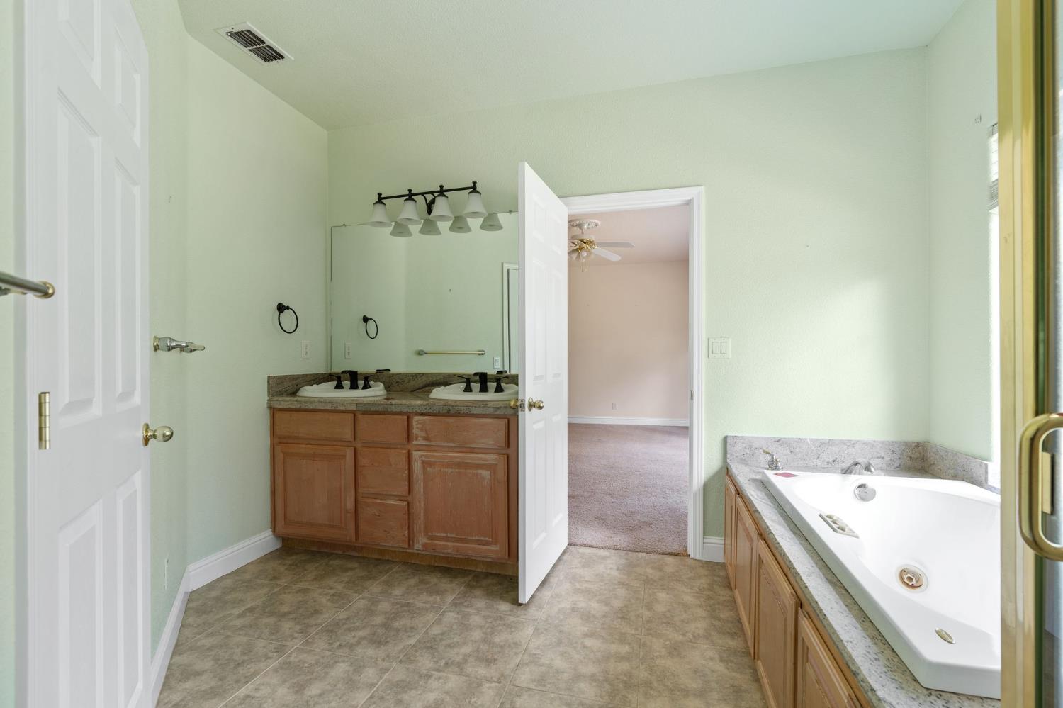 4410 Rossler Road Placerville, CA 95667 - Photo 24 of 35 a bathroom with a granite countertop sink and a mirror