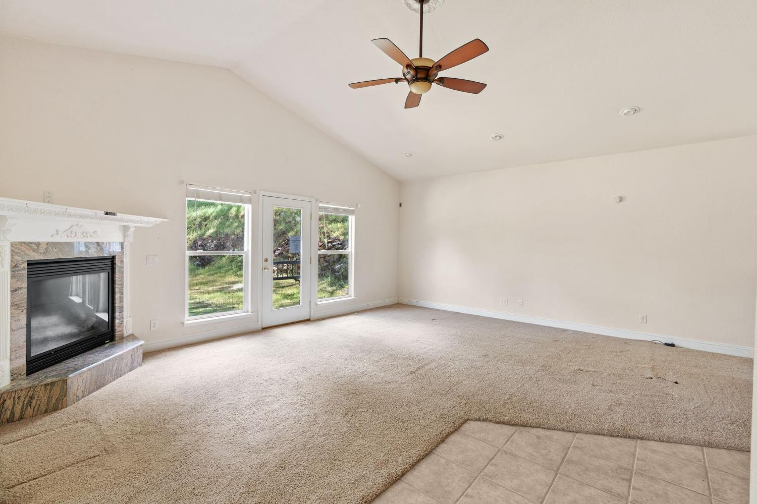 4410 Rossler Road Placerville, CA 95667 - Photo 9 of 35 a view of an empty room with a fireplace and a window