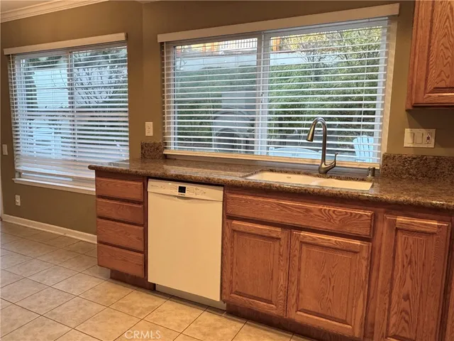 a kitchen with granite countertop cabinets and large window