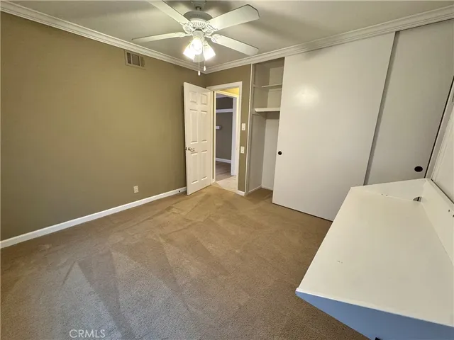 a view of a livingroom with a ceiling fan & entryway