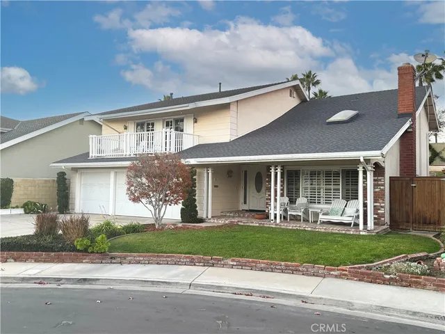 a front view of a house with a yard and potted plants