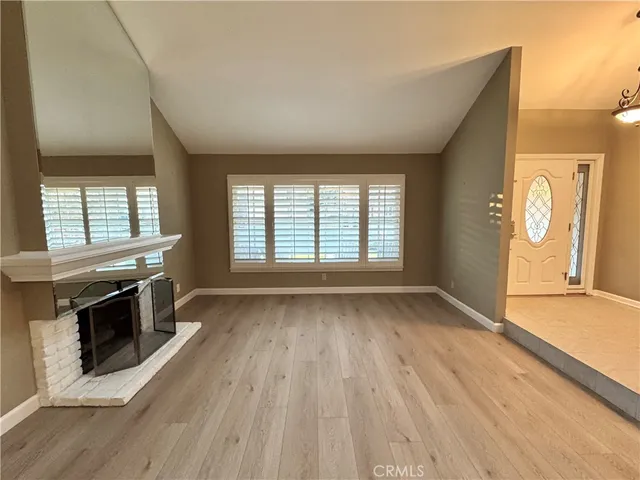 an empty room with wooden floor and fireplace