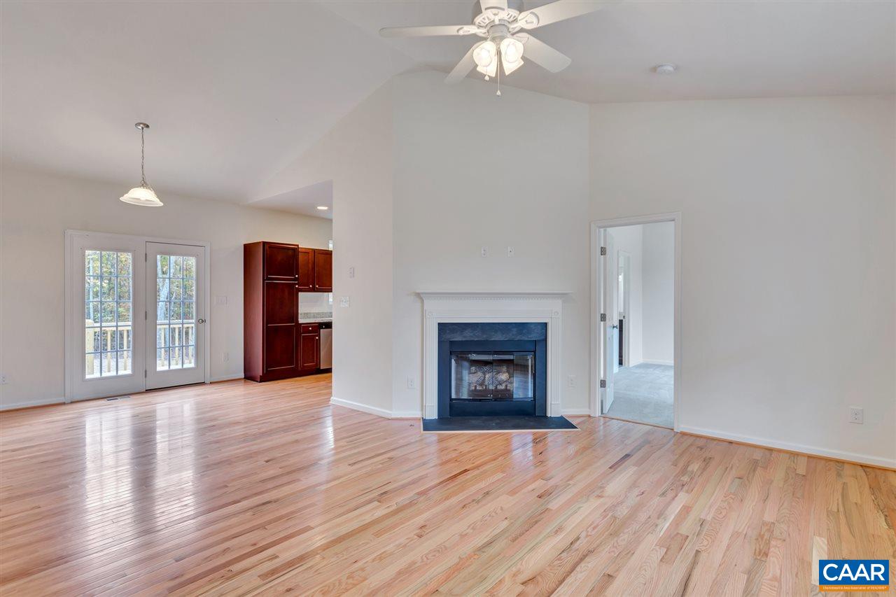 2235 Swift Run Road Ruckersville, VA 22968 - Photo 6 of 21 an empty room with wooden floor fireplace and windows