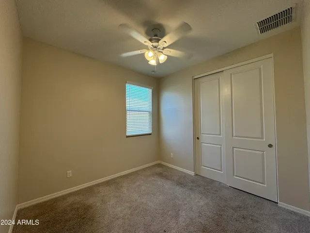 an empty room with windows and fan