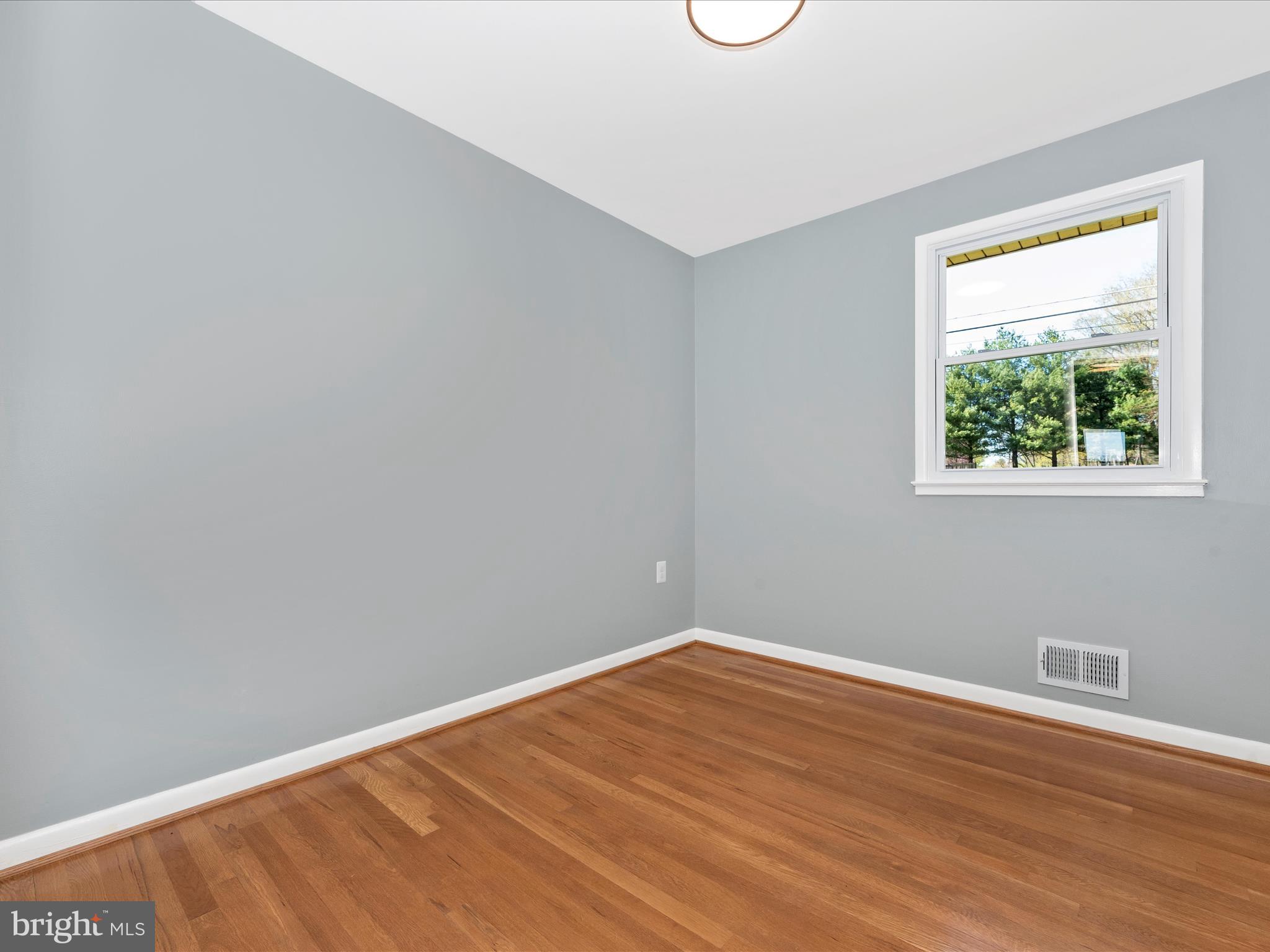 15224 Ganley Road Boyds, MD 20841 - Photo 31 of 62 a view of an empty room with wooden floor and a window