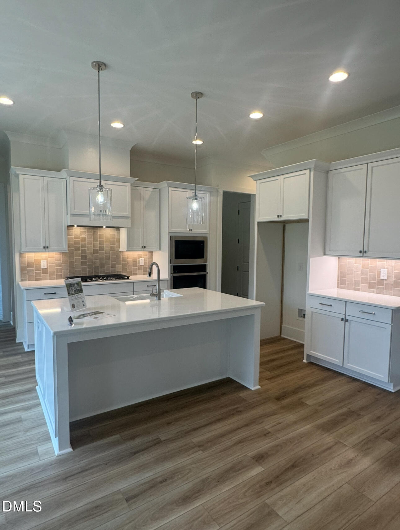 1037 Azalea Garden Circle Raleigh, NC 27603 - Photo 5 of 24 a large kitchen with kitchen island a sink dishwasher a refrigerator and a oven with wooden floor
