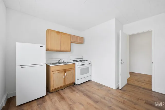 a kitchen with a refrigerator and a stove top oven
