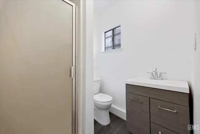 a bathroom with a toilet a sink and mirror
