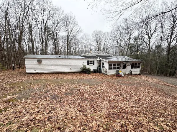 a view of house with outdoor space and trees in the background
