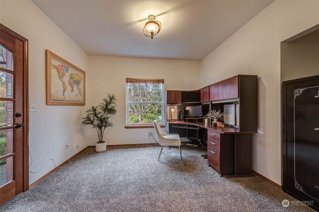 a view of a workspace with furniture and a window