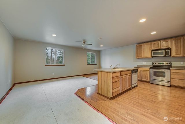 a kitchen with granite countertop a stove a sink and a refrigerator