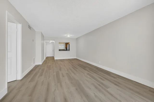 a view of empty room with wooden floor