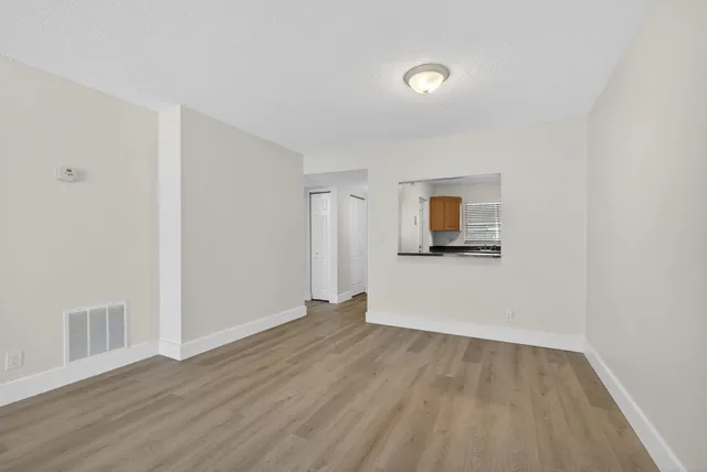 a view of empty room with wooden floor