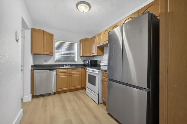 a kitchen with a refrigerator sink and cabinets