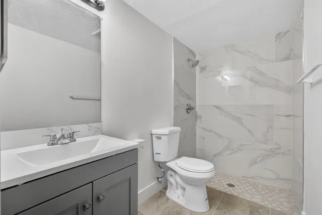 a bathroom with a sink a toilet and shower