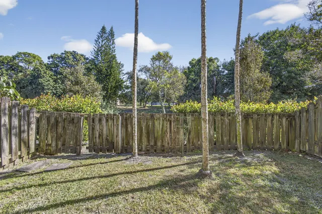 a view of a lake with a house and wooden fence