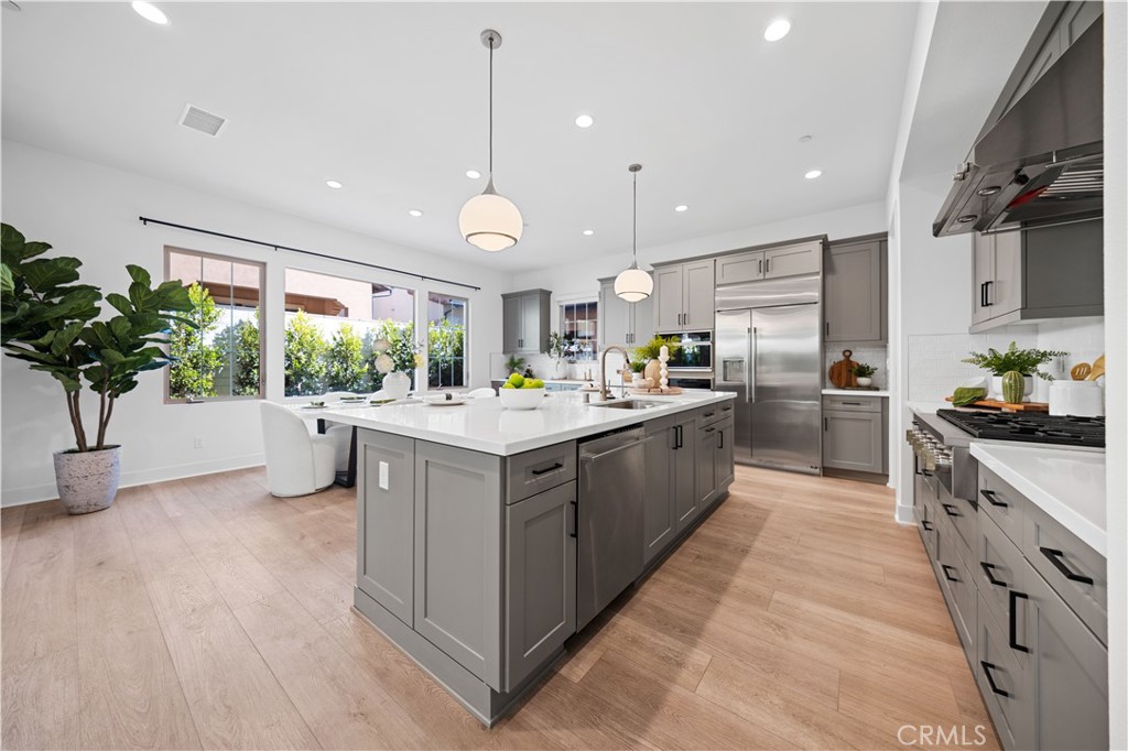 210 Sutters Mill Irvine, CA 92602 - Photo 14 of 46 a large kitchen with stainless steel appliances kitchen island a large counter top a sink a window and a potted plant