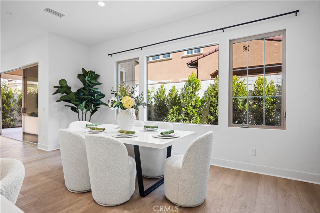 210 Sutters Mill Irvine, CA 92602 - Photo 24 of 46 a dining room with furniture potted plants and wooden floor