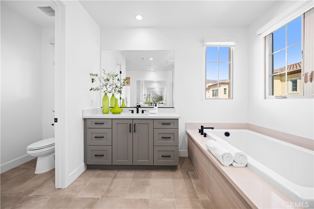 210 Sutters Mill Irvine, CA 92602 - Photo 32 of 46 a spacious bathroom with a double vanity sink a mirror a bathtub and a toilet