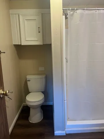 a bathroom with a toilet and a mirror