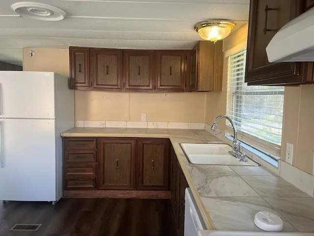 a kitchen with a refrigerator and a sink