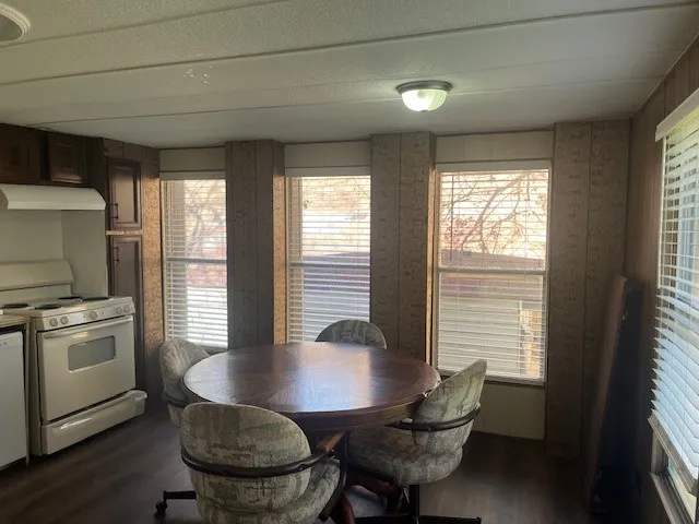 a kitchen with a table chairs and a wooden floor