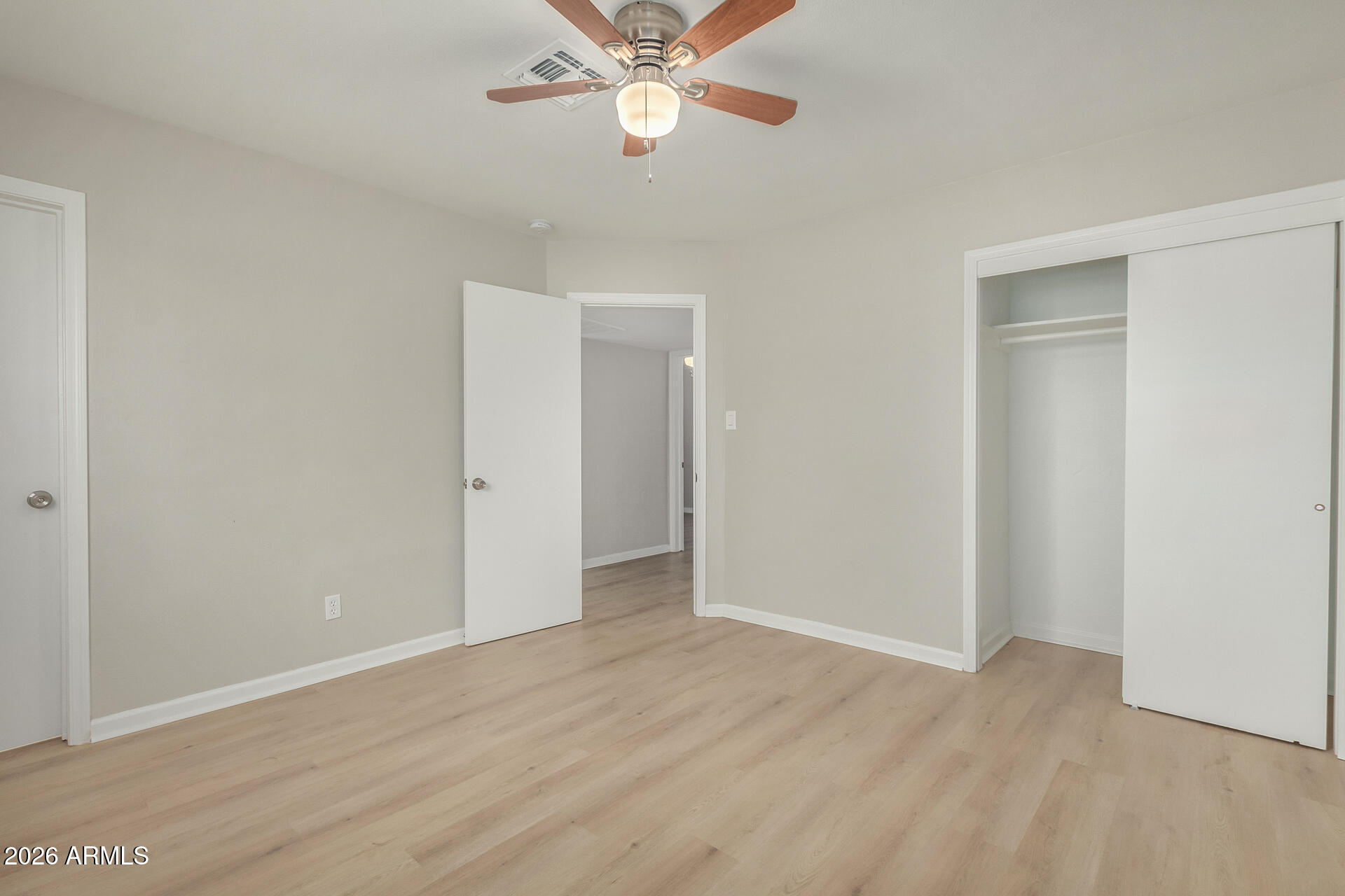 4911 East Culver Street Phoenix, AZ 85008 - Photo 14 of 26 an empty room with wooden floor closet and fan