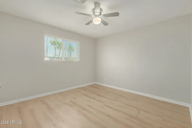 an empty room with a window and a ceiling fan