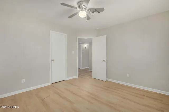 a view of an empty room and chandelier fan