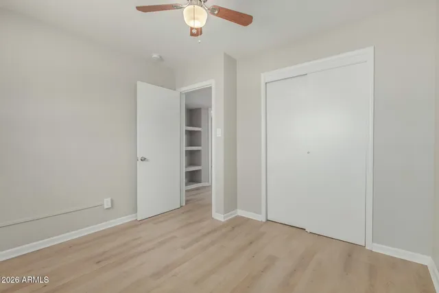 an empty room with a hardwood and ceiling fan
