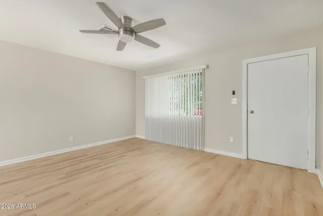 an empty room with fan and windows