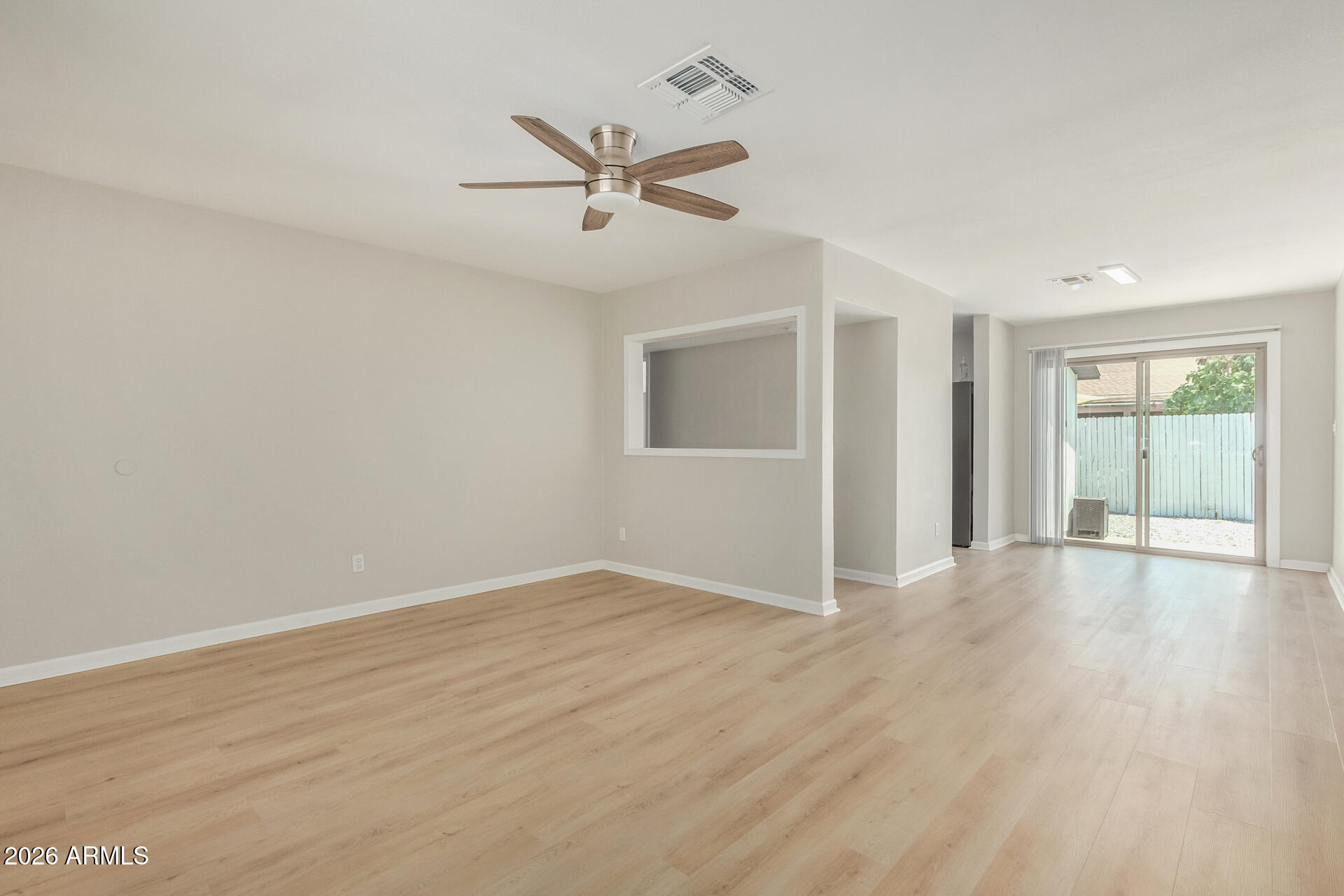 4911 East Culver Street Phoenix, AZ 85008 - Photo 8 of 26 an empty room with wooden floor fan and windows