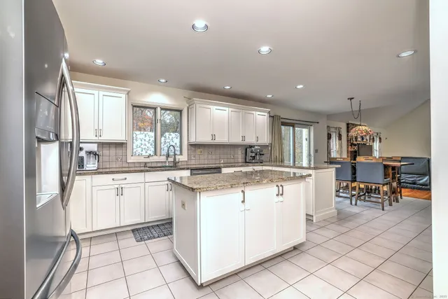 a kitchen with stainless steel appliances granite countertop a refrigerator and a stove top oven