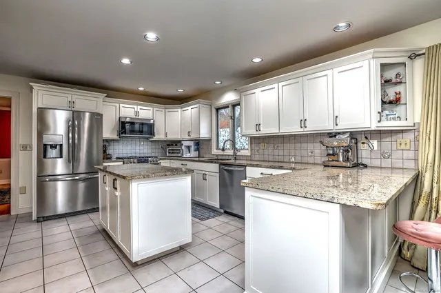 a kitchen with a sink a refrigerator a microwave and cabinets