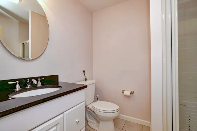 a bathroom with a toilet a sink and a mirror