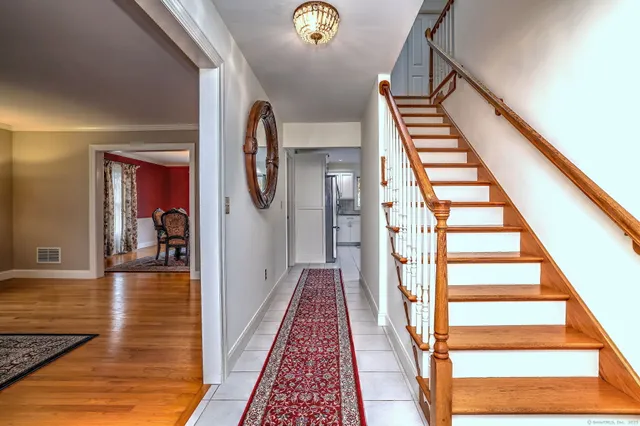 a view of staircase with lots of frames on wall and a rug