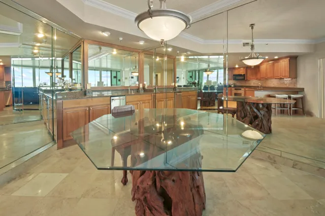 a view of a dining room with furniture a chandelier and kitchen view