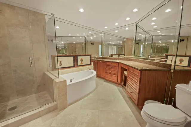 a bathroom with a granite countertop sink a toilet a mirror and shower